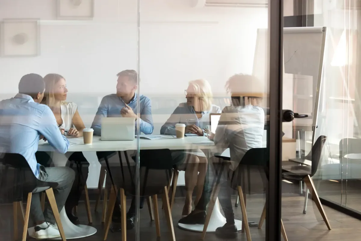 A team meeting behind a glass partition