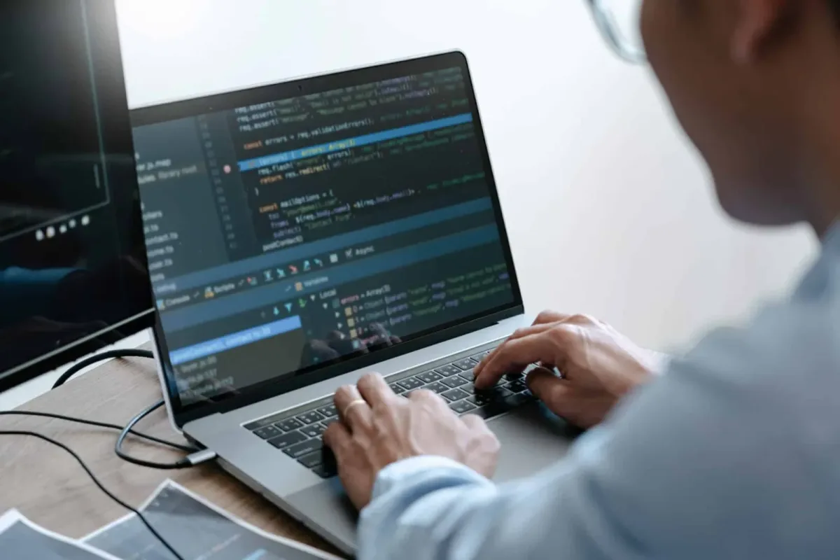 A programmer working at a computer screen